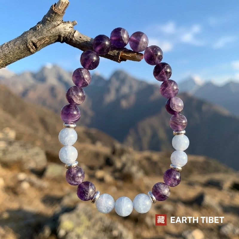 Amethyst aquamarine bracelet held against the sky, light passing through the purple beads