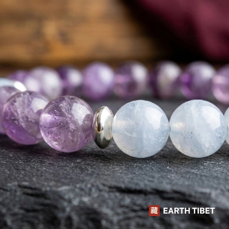 Close view of natural amethyst and milky aquamarine beads either side of a silver spacer