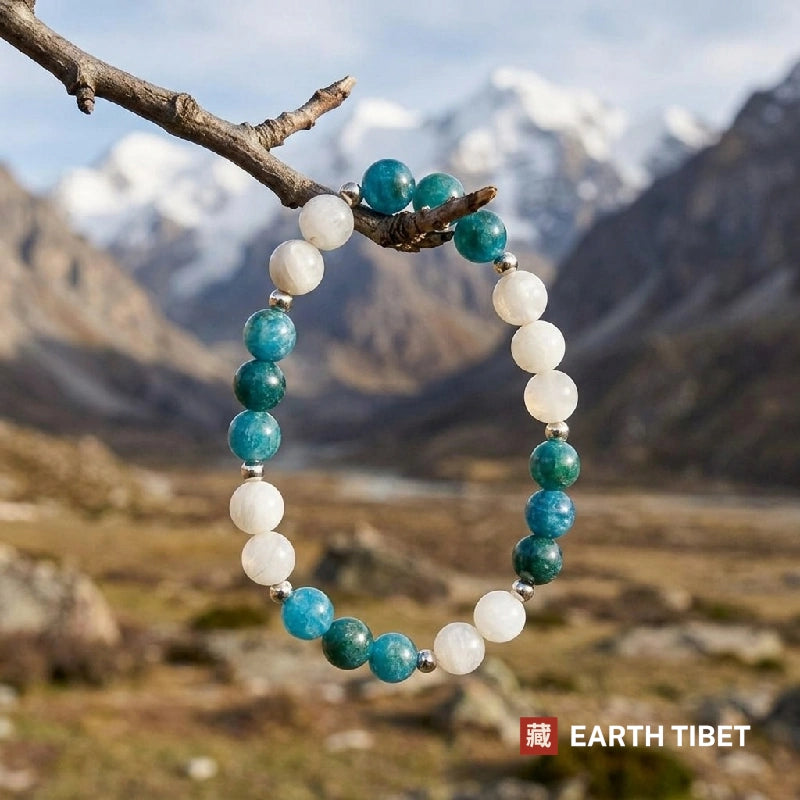Apatite and white agate stretch bracelet against carved wood