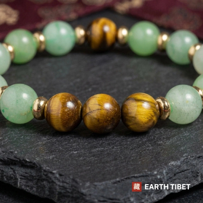 Green aventurine and tiger's eye bracelet in 8mm beads with gold-toned spacers, close up on slate