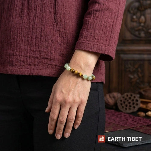 Aventurine tiger eye bracelet photographed against carved wood
