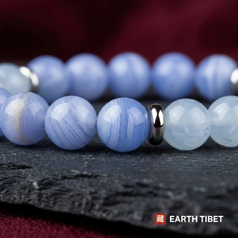 Pale blue lace agate beads showing white lace banding beside translucent aquamarine