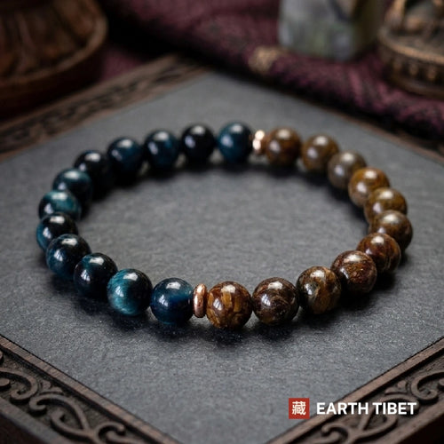 Blue tiger's eye and bronzite stretch bracelet on a carved wooden surface