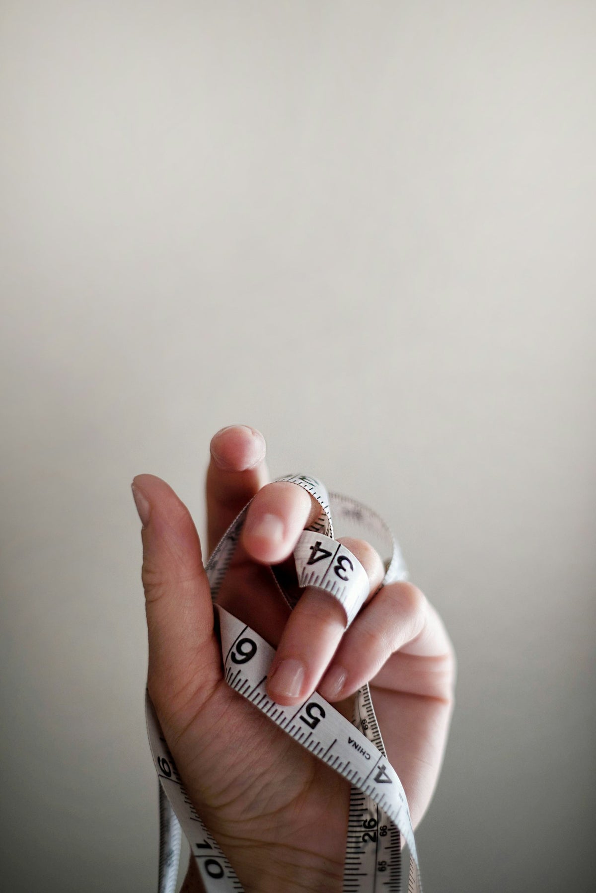 A hand with a soft tape measure wrapped around the wrist