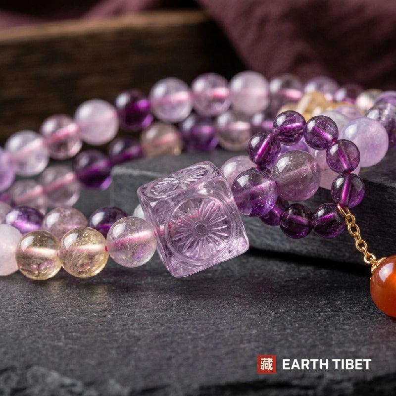 Close view of the carved square amethyst bead among purple and golden quartz beads