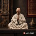 Ceramic scholar monk statue standing mid-turn with an open folding fan