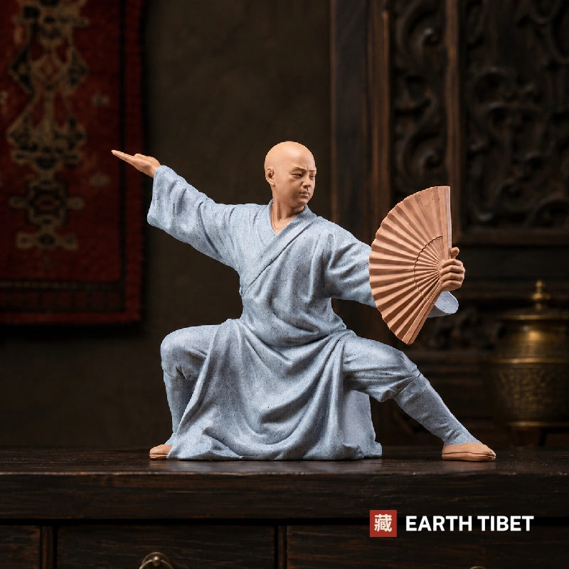 Ceramic monk statue seated with palms together in meditation