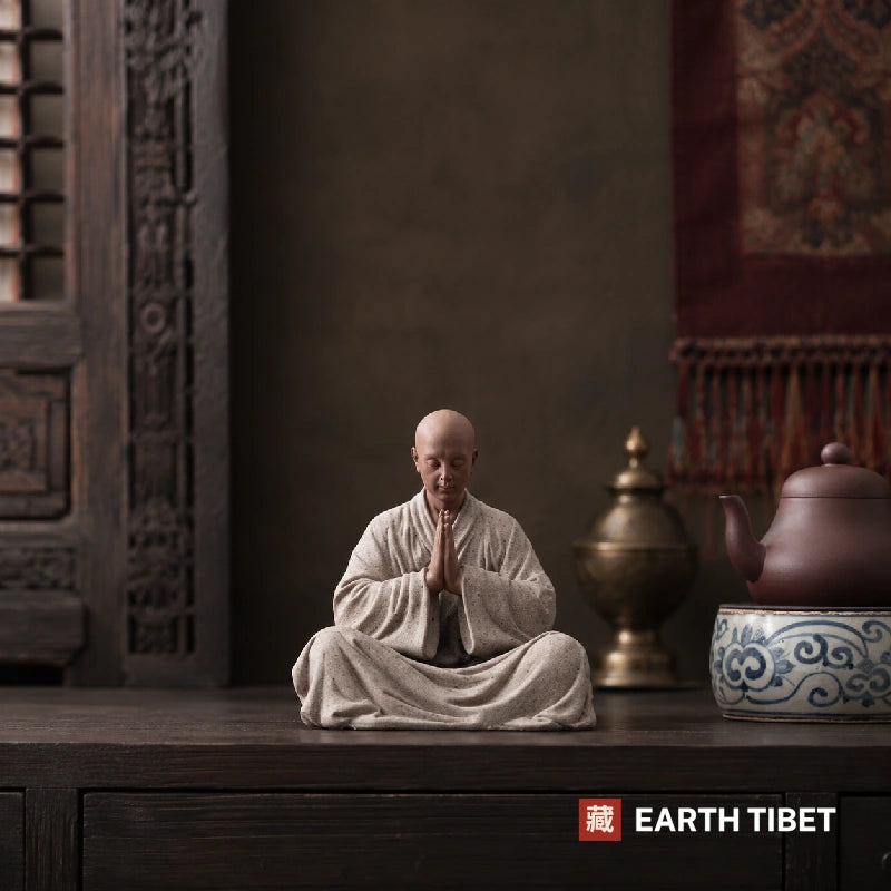 Close up of the sandstone-textured robe on a Chinese scholar monk statue