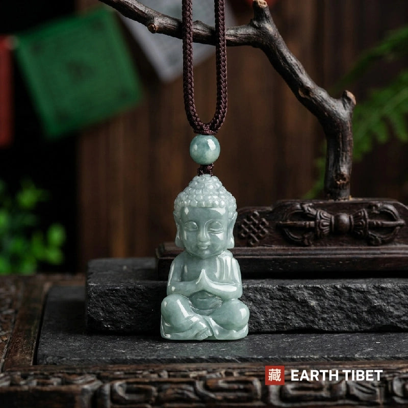 Carved jadeite Buddha necklace, a seated Buddha with palms together, hanging on a braided cord