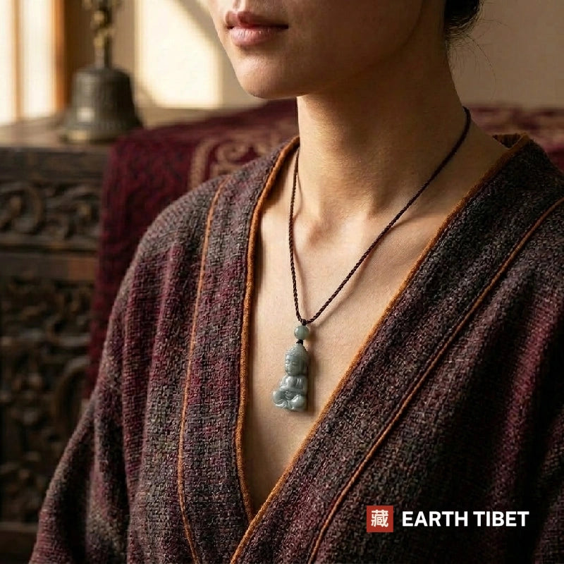 Woman wearing the carved jadeite Buddha necklace over a knitted wrap