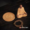 What is included: ceramic monk with hands in the lap, woven rattan mat and a mala