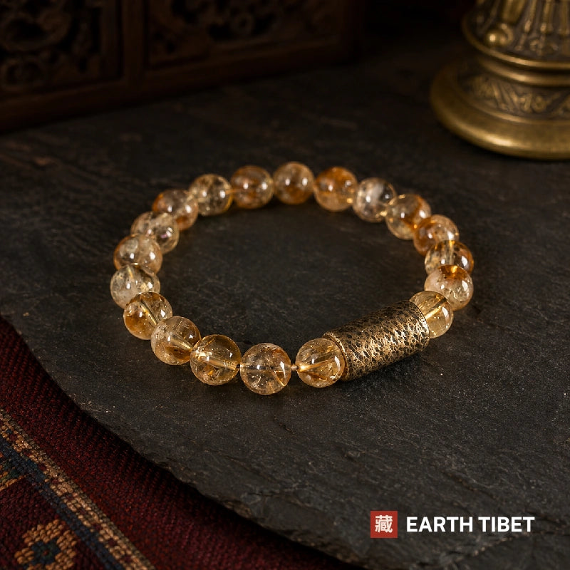 Citrine bracelet in pale gold beads with a single textured gold barrel, on slate