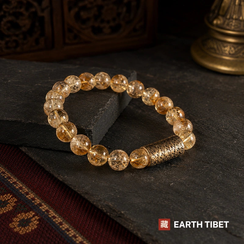 Citrine abundance bracelet in a loop on slate beside a patterned carpet