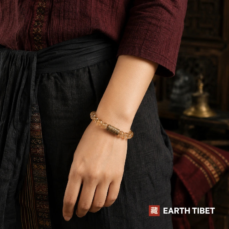 Citrine bracelet worn on a wrist against a maroon top and black skirt