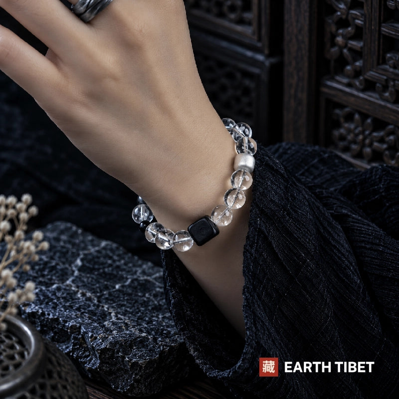 Clearing and grounding bracelet worn on a wrist, the ebony cube sitting flat