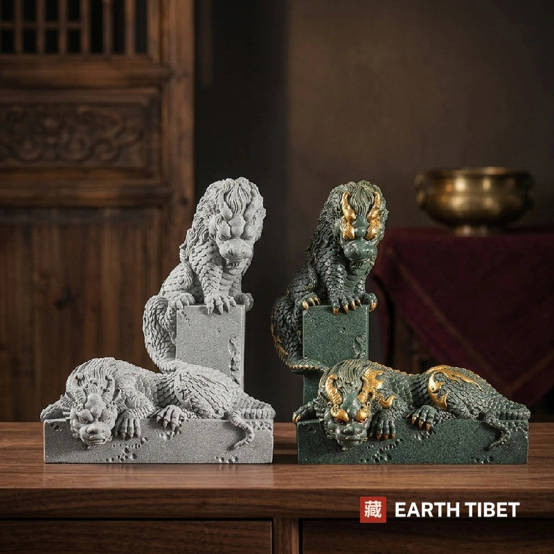 Four coiled dragon statues in grey and gold-accented green sandstone on a wooden sideboard
