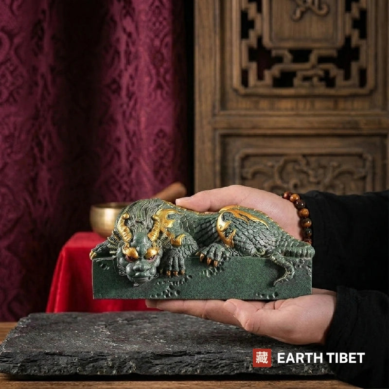 Horizontal coiled dragon statue held in one hand to show its size and weight