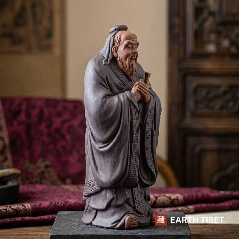 Confucius statue standing in a slate grey robe with hands folded in the gongshou salute
