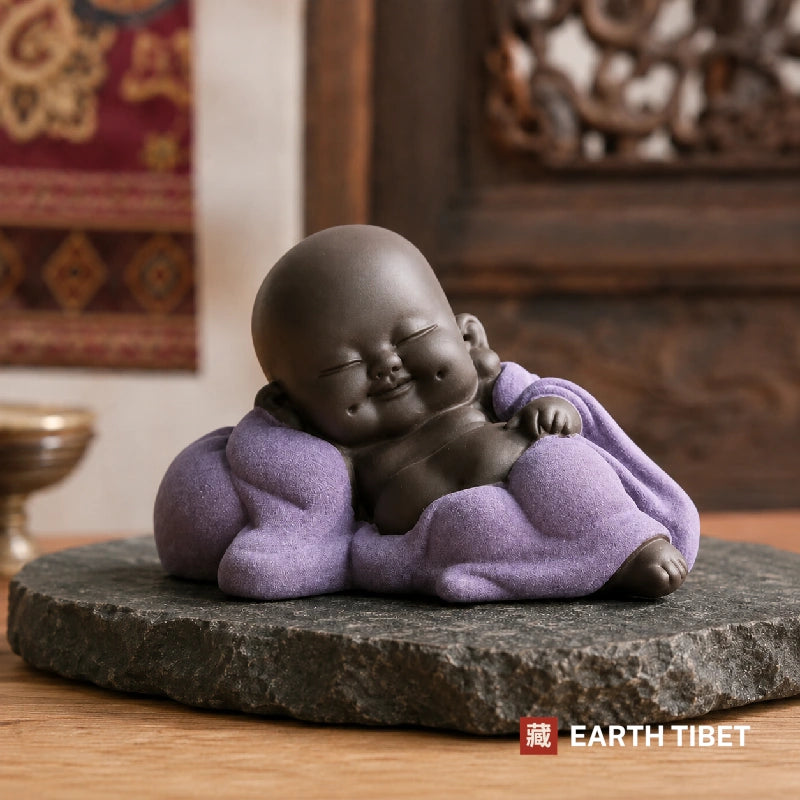 Laying baby laughing Buddha in a purple robe, propped on one elbow