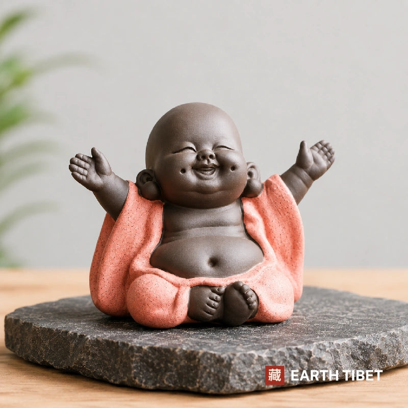 Sitting baby laughing Buddha in a coral robe with both arms raised