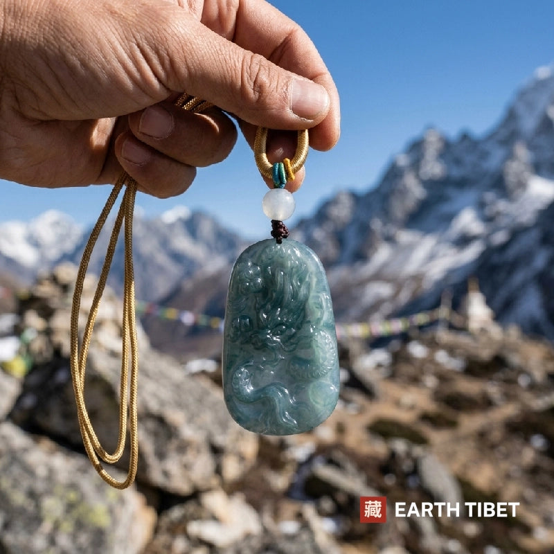 Blue water jade dragon pendant held up against a Himalayan ridge and prayer flags