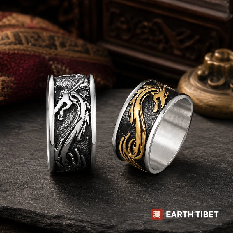 Steel and gold-tone dragon band rings on slate with brocade behind