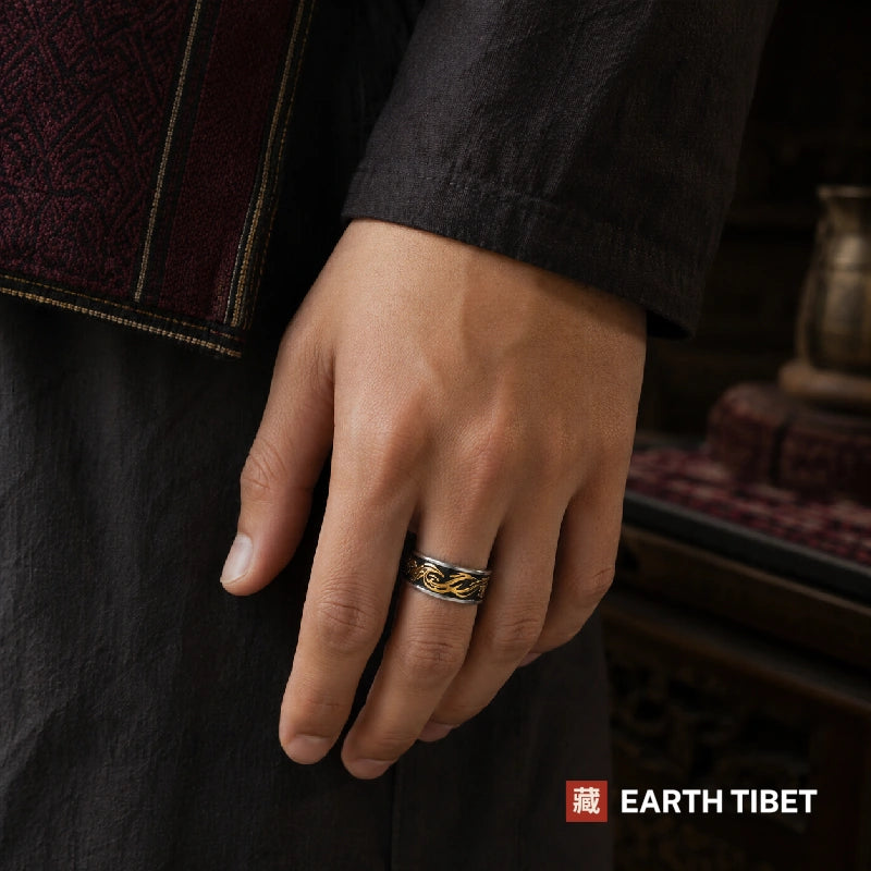 Gold-tone dragon band ring worn on a hand against dark linen