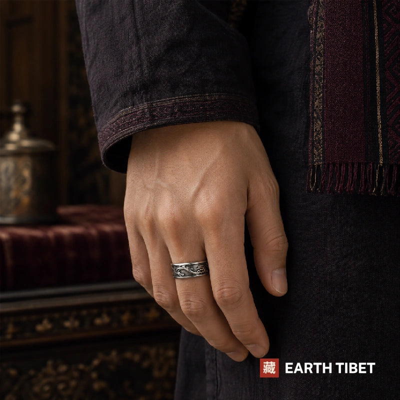 Steel dragon band ring worn on a hand beside a maroon sleeve
