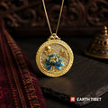 Blue lotus openwork pendant hanging on a box chain against carved wood