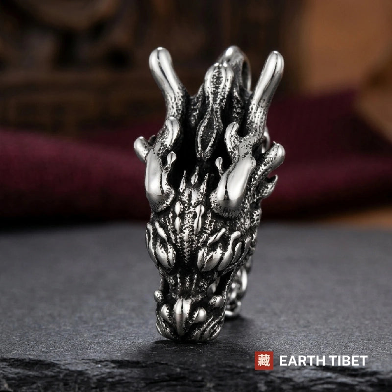 Front view of the dragon head pendant showing swept-back antlers and open jaw