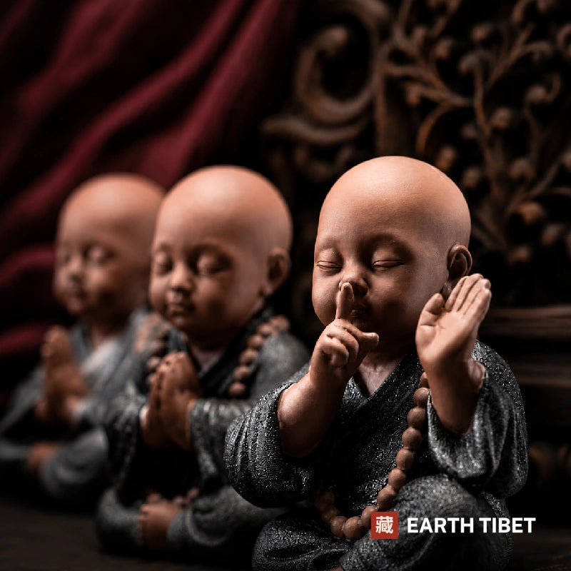 Row of ceramic monk figures with the speak-no-evil monk sharp in the foreground