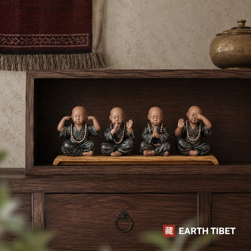 The four monks ceramic set displayed in a dark wood console recess beside a brass jar