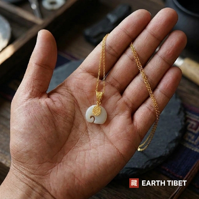 Jade fu elephant necklace and its chain lying in an open hand