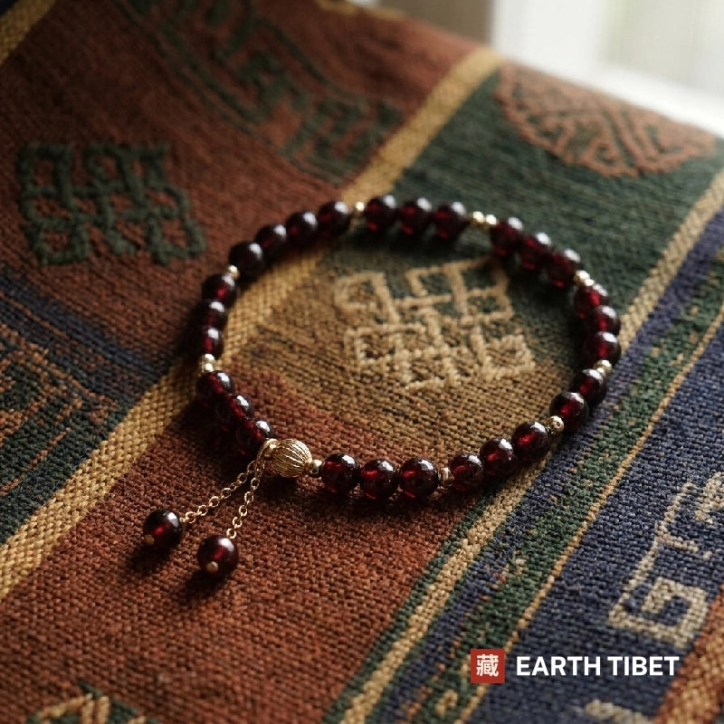 Thin garnet bracelet laid on a woven Tibetan textile