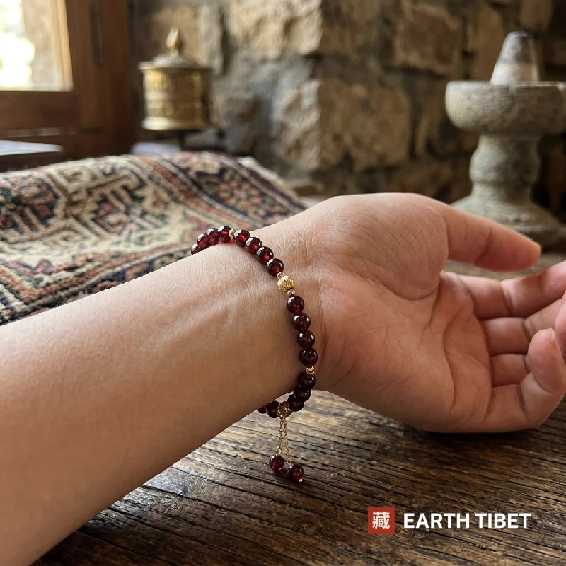Garnet vitality bracelet worn on a wrist, sitting flat and low profile