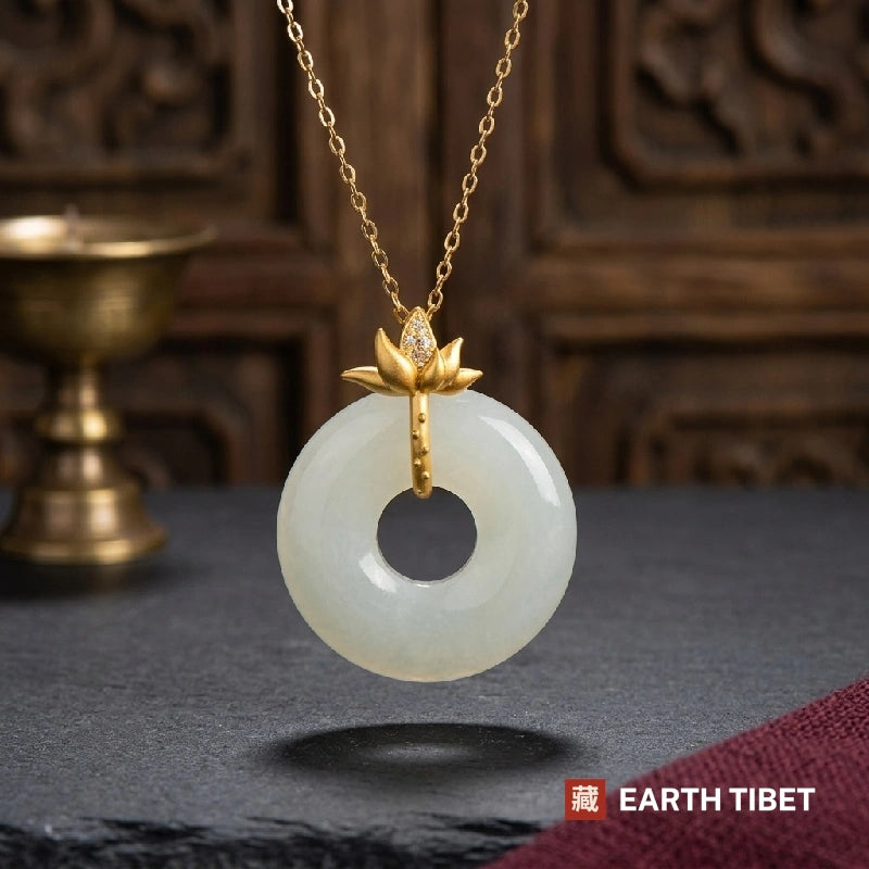 White agate peace buckle necklace with a gold lotus bail, hanging against dark slate