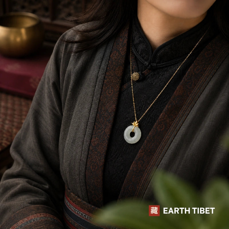 Woman wearing the gold lotus peace agate necklace over a dark jacket