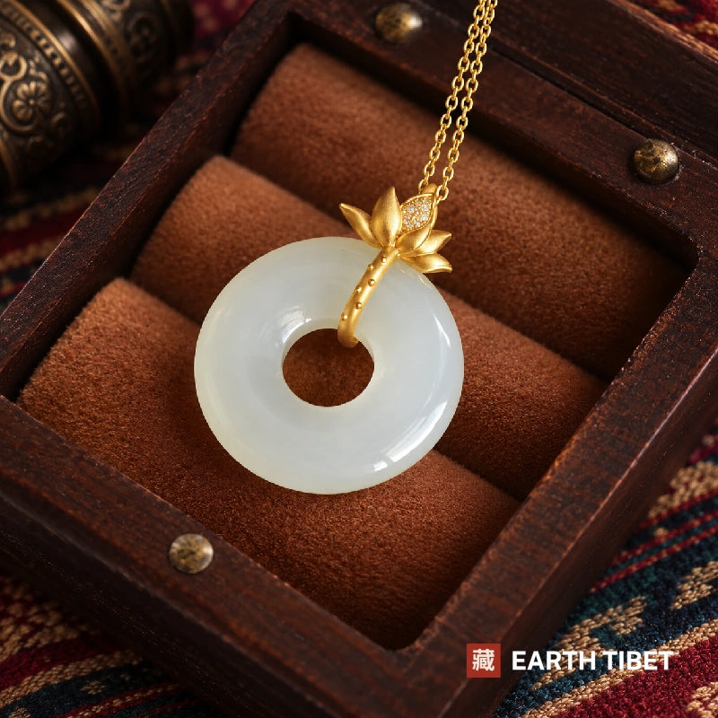 Gold lotus peace buckle pendant in a wooden box, showing the pave set stones on the lotus leaf