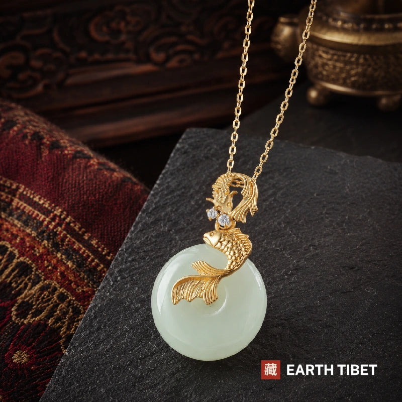 Golden koi jade necklace, two gold fish over a pale jade disc on a fine chain