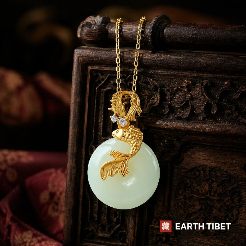 Koi jade pendant hanging against a carved wooden panel and red silk