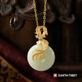 Two gold koi and a jade disc pendant, one fish rising and one diving, with set stones between