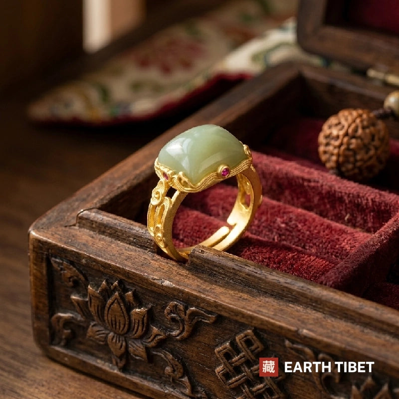 Green chalcedony ring resting in a carved wooden jewellery box