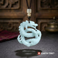 Carved jade dragon necklace hanging free, showing the pierced openings through the coiled body