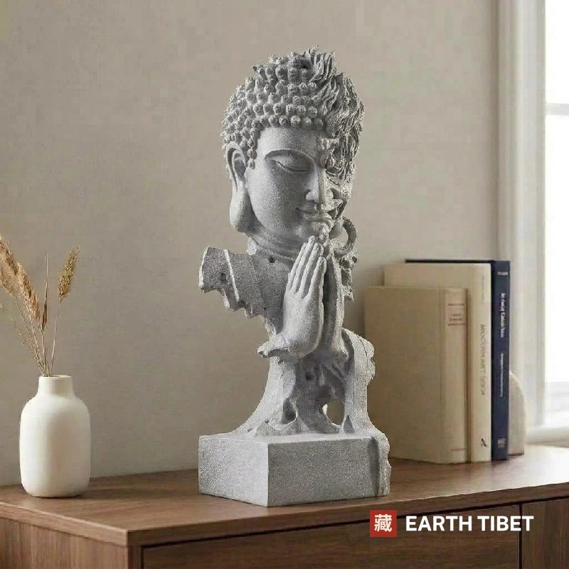 Statue on a sideboard beside books, turned so only the calm Buddha half shows