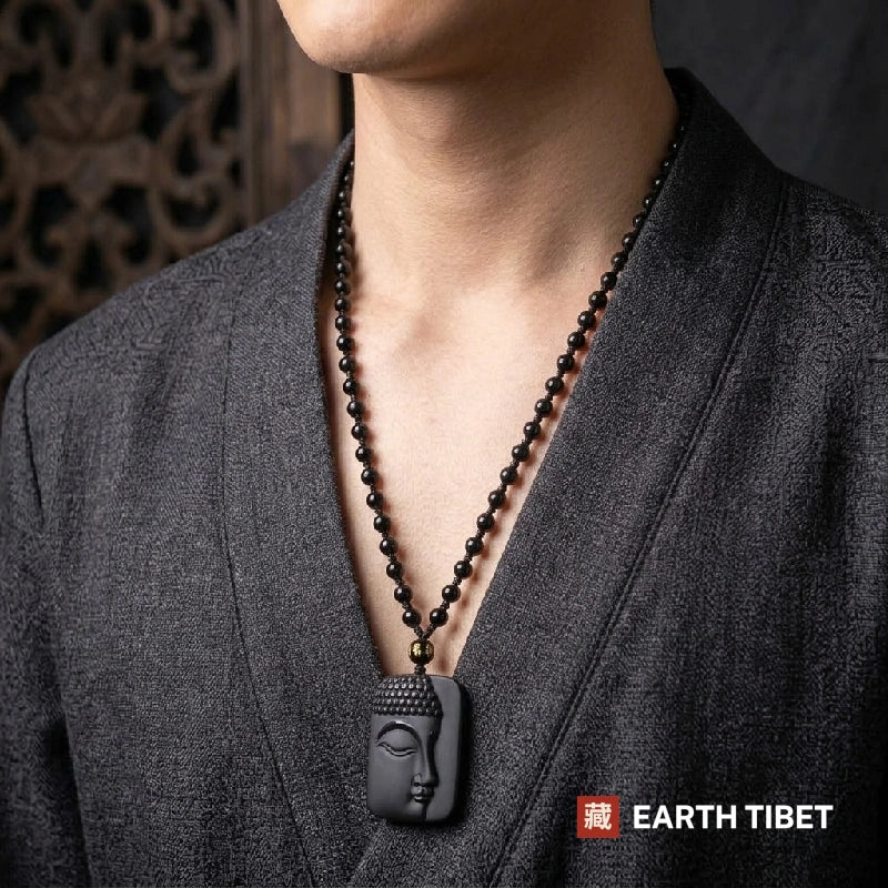 Man wearing the obsidian Buddha protection necklace on a long beaded strand