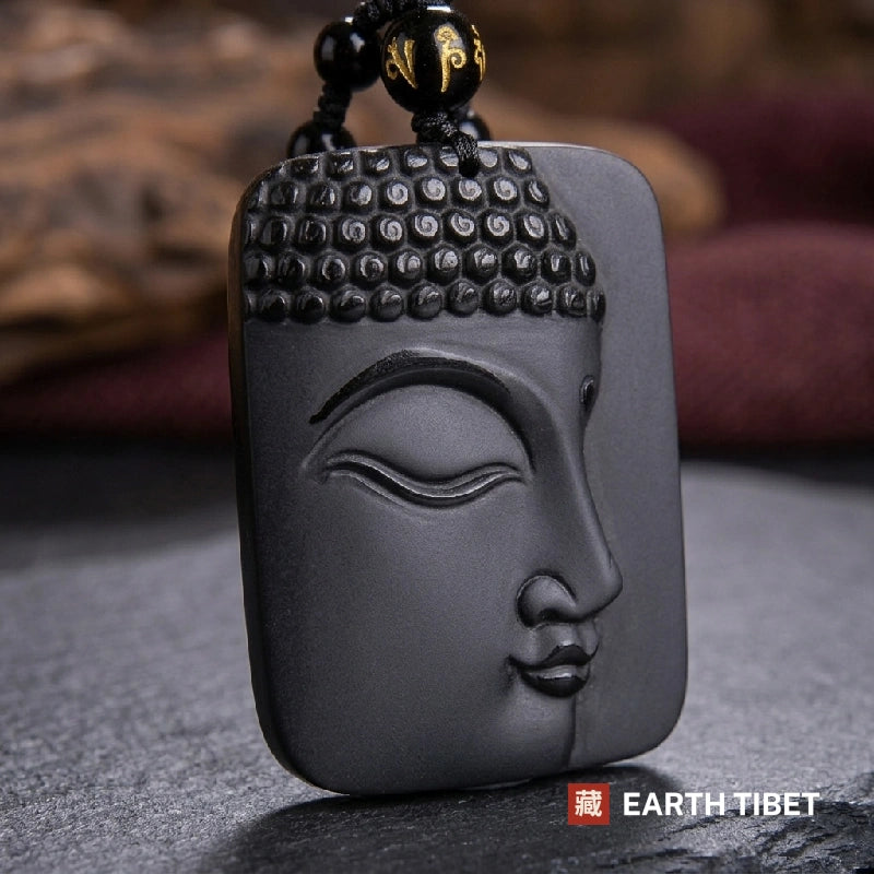 Obsidian Buddha pendant showing matte carved face beside a polished blank field
