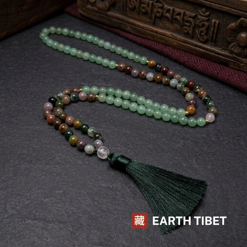 108 bead mala laid on slate, pale green runs breaking into multicoloured agate