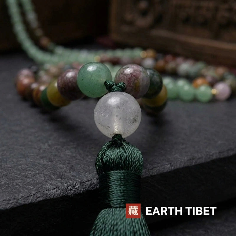Close view of the clear quartz guru bead above the dark green silk tassel
