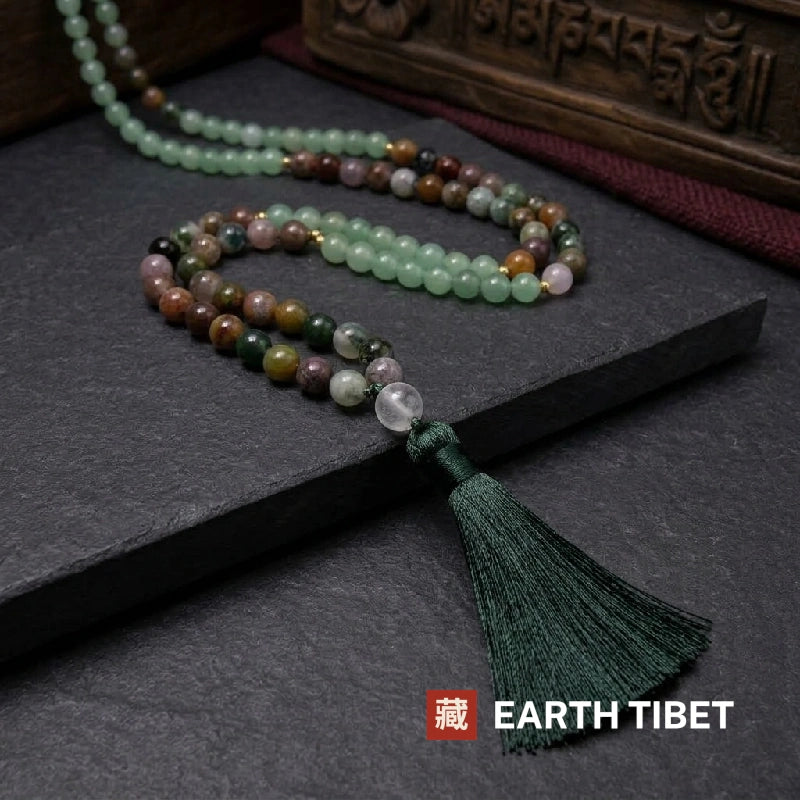 Mala coiled on slate showing the gold-toned spacer beads between sections