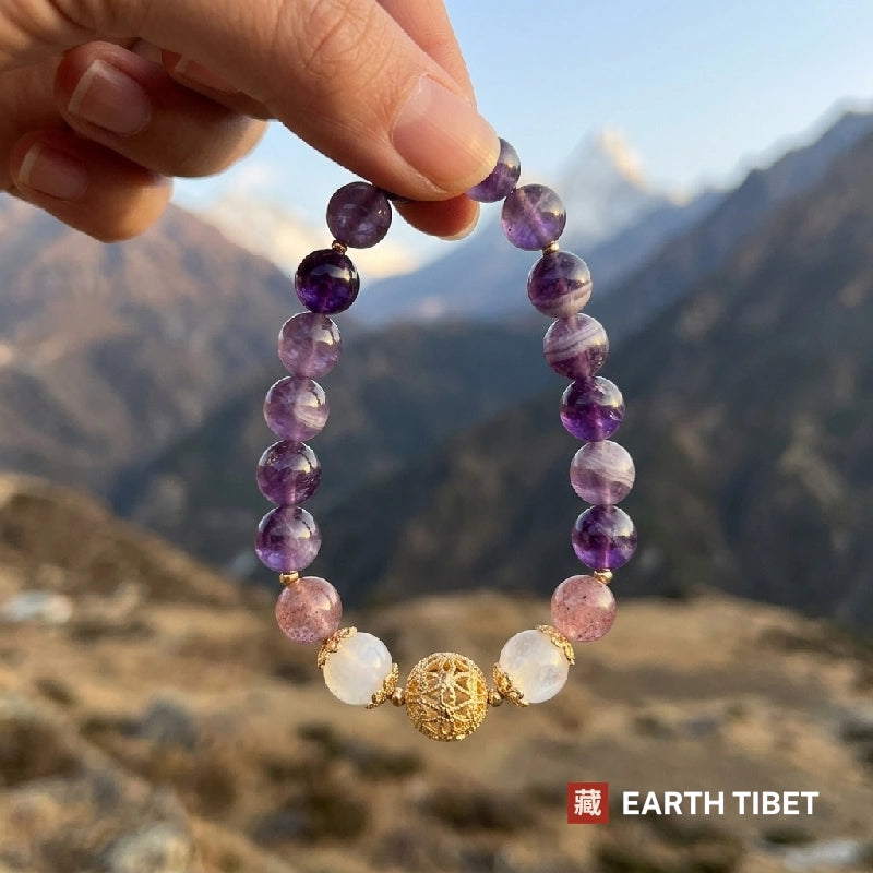Banded amethyst and moonstone bracelet held against the sky in the mountains